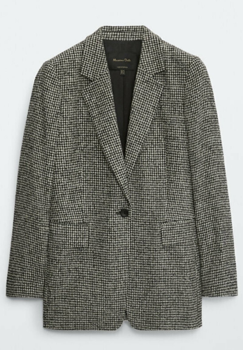Zwart-wit geblokte blazer met een notch lapel, sluitsysteem met een enkele knop en twee voorkgedeelte zakken. Gemaakt van een gestructureerde stof.
