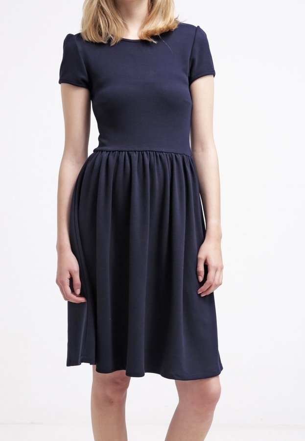 Robe bleu marine à manches courtes, à col rond et à jupe froncée. Confectionnée dans un tissu flexible à texture lisse.