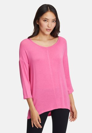 Roze, lange mouwen top met een brede halslijn en een losse pasvorm. Heeft een iets langere achterkant en een zachte, gladde textuur.