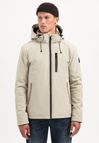 Lichtbeige zip-up jacket met een capuchon, verstelbare koordjes en voorzakken. Heeft zwarte ritsen en een gestructureerde stof.