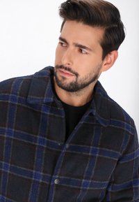 Navy-kariertes Wollsakko mit blauen und roten Linien, einem Kragen, Knopfverschluss und einer strukturierten Oberfläche.