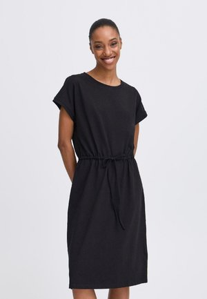 Black cotton dress with short sleeves, relaxed fit, and drawstring waist. Smooth texture, knee-length with no notable patterns or accents.