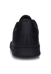 Bageste udsigt af en simpel sort sneakersko med polstret krave og glat hæl, sat mod en hvid baggrund.