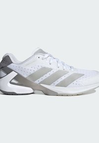 Biele atletické topánky s priedušným sieťovaným zvrškom, striebornými akcentmi a jedinečným, zakriveným dizajnom podrážky s textúrovaným povrchom.