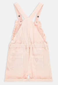 Roze denim tuinbroek met ruches aan de schouderbanden, elastische taille en twee achterzakken, voorzien van een klein logo-embleem. Zachte textuur en lichte kleur.