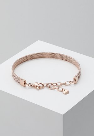 Bracelet en maille en or rose avec chaîne réglable et fermoir mousqueton, présenté sur un socle géométrique blanc sur fond gris.