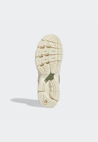 Sula i gummi med en texturerad yta i kräm- och gröntoner, med spår och mönster för grepp och dragkraft.