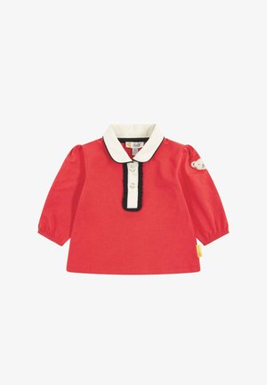 Red long-sleeve shirt with a white collar, black trim, and three button closure. Features a teddy bear patch on one sleeve. Soft cotton fabric.