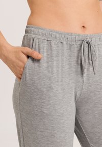Grijze joggingsbroek gemaakt van zacht, gestructureerd materiaal met een elastische tailleband en trekkoord, voorzien van zijzakken en een ontspannen pasvorm.