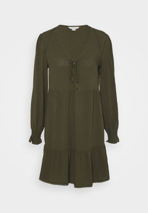 Robe vert olive à manches longues, encolure en V, lien à cordon avec perles, ourlet à volants à étage et motif texturé à pois sur toute la surface.