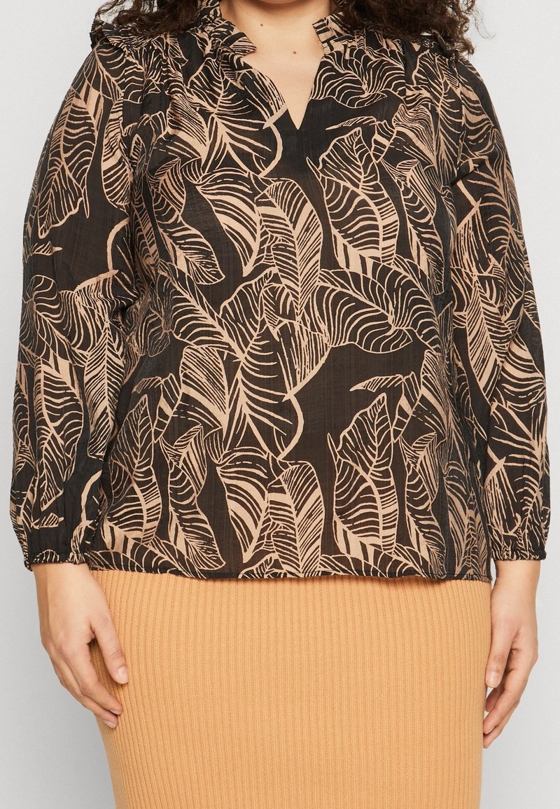 Svart topp med V-ringning, långa ärmar och ett lövtryck i ljusbeige. Texturerad tyg med rynkade detaljer vid axlarna.