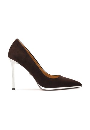 Décolleté in camoscio marrone con tacco alto e punta affusolata, accentuata da un dettaglio in metallo argento sul tallone. La scarpa presenta un profilo elegante e una texture liscia.