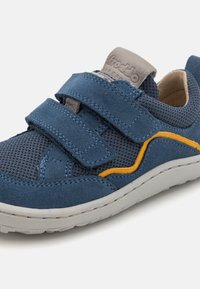 Blaue Wildleder-Sneaker mit atmungsaktivem Mesh, ausgestattet mit zwei verstellbaren Klettverschlüssen und kontrastierenden gelben Akzenten an der Seite. Flexible Gummisohle.