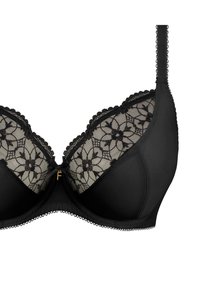 Sostén negro con encaje floral superpuesto, copas acolchadas y bordes ondulados. Cuenta con tirantes ajustables y un detalle central en tono dorado.