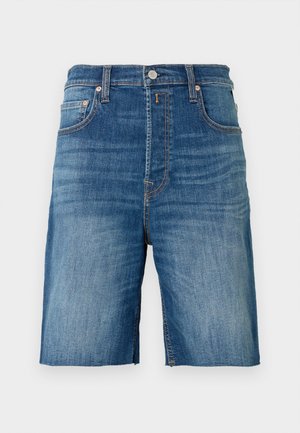 Shorts vaqueros con cintura de tiro medio, lavado azul clásico, cinco bolsillos y costuras contrastantes. Presentan un dobladillo sin rematar.