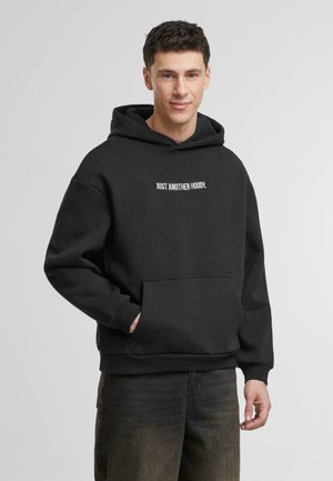 Schwarzer Kapuzenpullover aus weichem Stoff, mit einer Kängurutasche vorne und weißem Text "JUST ANOTHER HOODIE." auf der Brust. Entspannter Schnitt.