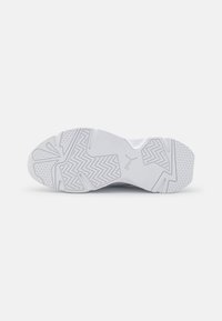 Suola di scarpa sportiva bianca con modelli di presa testurizzati e accenti sottili, caratterizzata da un logo centrale e diverse texture superficiali per la trazione.