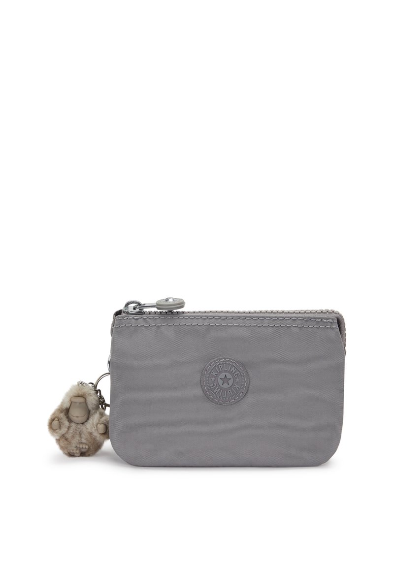 Portefeuille en nylon gris avec une texture lisse, fermeture éclair et un logo circulaire. Il possède un charme en fourrure attaché à la fermeture éclair.