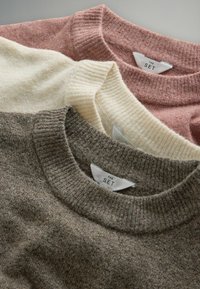 Tre maglioni a girocollo lavorati a maglia nei colori rosa, crema e marrone. Ognuno con colli a coste e etichette con la scritta "THE SET".