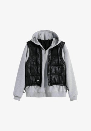 Grijze zip-up hoodie gelaagd met een zwarte gewatteerde mouwloze vest met drukknoopsluitingen en zakken, weergegeven op een witte achtergrond.