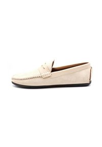 Mocassins en suède beige avec un bout rond, présentant des détails de couture et une semelle lisse et discrète. Design simple sans accents en métal.