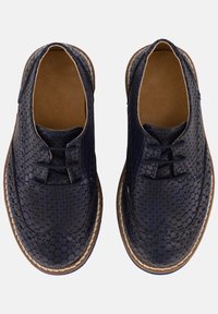 Tmavě modré kožené boty s texturovaným vzorem včelího plástu, kulatá špička, šněrovací design a kontrastní světle hnědá podrážka.