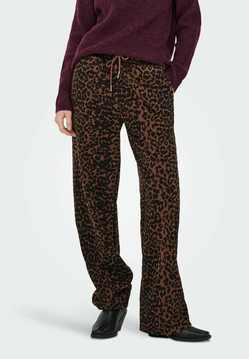 Brune og sorte leopardmønstrede bukser med elastisk talje, afslappet pasform og blød tekstur, parret med en lilla strikbluse.