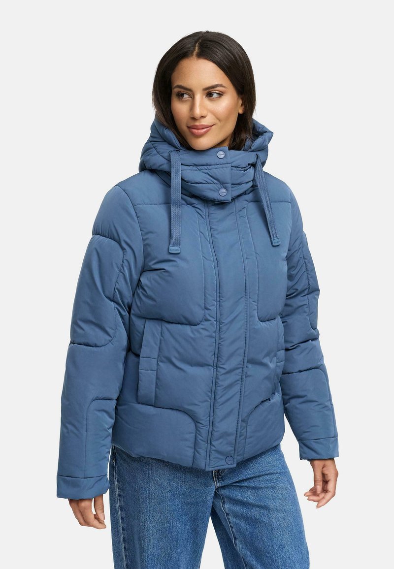 Mjuk, blå fodrad jacka med huva, hög krage, framfickor och knäppning med knappar. Tillverkad av ett mjukt och slätt material.