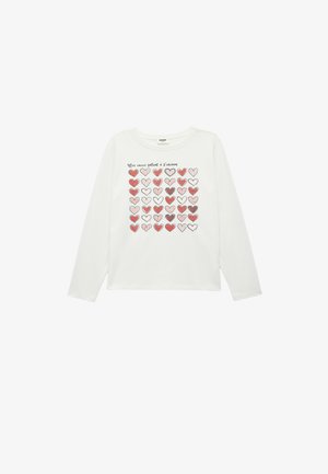 Camisa de manga larga blanca con un diseño de una cuadrícula de corazones rojos y rosas en varios patrones, con texto impreso encima del diseño. Material de algodón suave.