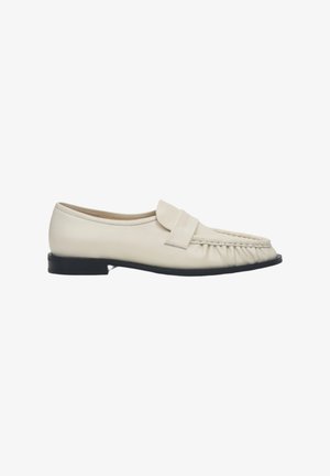 Cremfarbene Lederloafers mit runder Zehenpartie und gefalteten Details. Verfügt über eine flache schwarze Sohle und einen breiten dekorativen Riemen über dem Innenfuß.