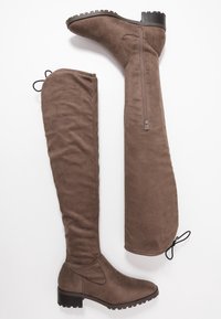 Botas marrones hasta la rodilla en suave ante, con cremallera lateral, punta redonda y un tacón bajo con suela texturizada.