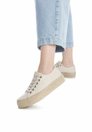 Zapatillas de plataforma de lienzo beige con una suela de yute texturizada, que presentan puntera redonda, diseño de cordones y ojales de metal visibles.