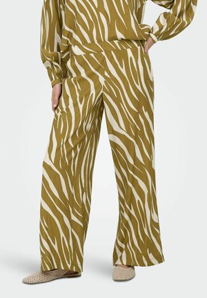 Wide-leg pants with an olive and white zebra print worn with matching top and beige woven slip-on shoes.