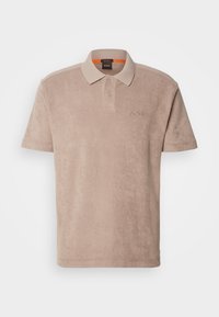 Polo beige à manches courtes avec deux boutons, col côtelé et logo BOSS brodé sur la poitrine gauche.