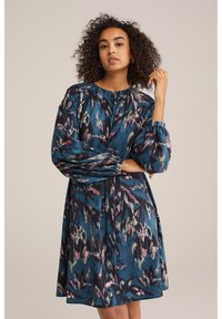 Rochie lungă cu mâneci, de culoare teal, cu un model floral în nuanțe de roz și verde. Are un decolteu plisat și mâneci evazate cu manșete cu nasturi.