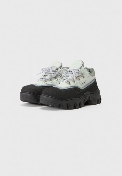 Wanderschuhe in einem hellgrünen und schwarzen Farbschema, mit einem gepolsterten Kragen, texturiertem Wildlederobermaterial und robustem Gummisohle.
