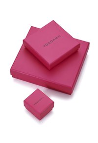 Cajas de regalo rosas de diferentes tamaños apiladas, con un acabado suave y un logo en relieve "YOKOAMII" en negro en las superficies superiores.
