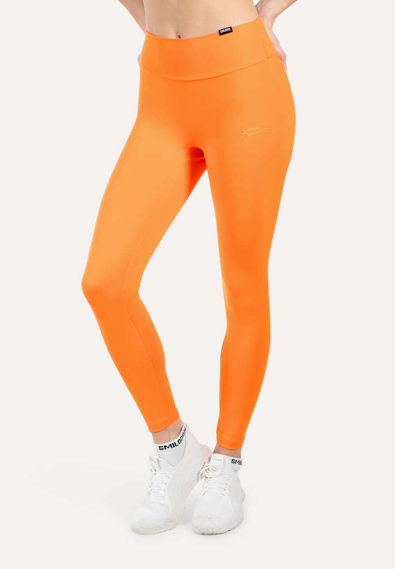 Feloranje leggings gemaakt van een glad, rekbaar materiaal met een hoge tailleband en een klein logo detail op de heup.