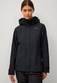 Giacca nera impermeabile con cappuccio. Caratterizzata da tasche con zip e polsini regolabili. Realizzata in un tessuto liscio e resistente con dettagli del logo.