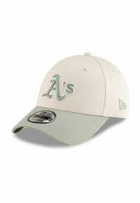 Gorra de béisbol crema con visera verde clara. Presenta un logotipo bordado de "A's" en verde a juego y cierre ajustable tipo snapback.