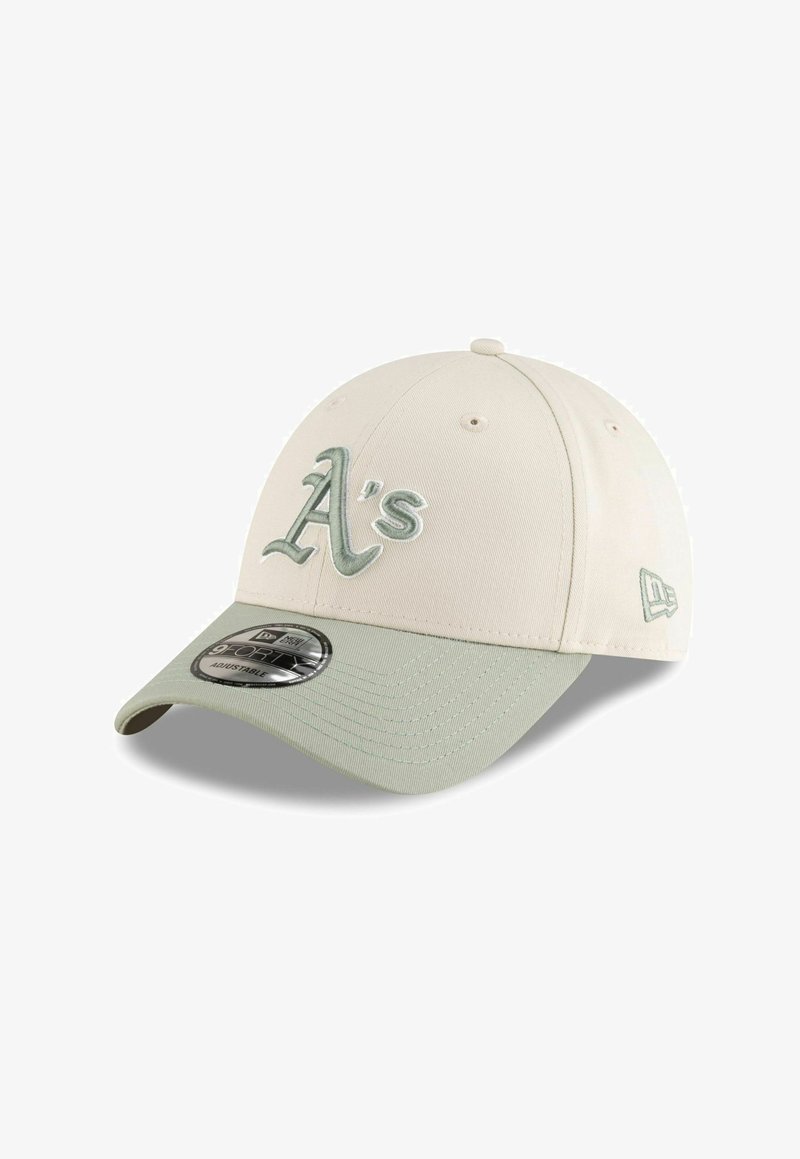 Gorra de béisbol crema con visera verde clara. Presenta un logotipo bordado de "A's" en verde a juego y cierre ajustable tipo snapback.