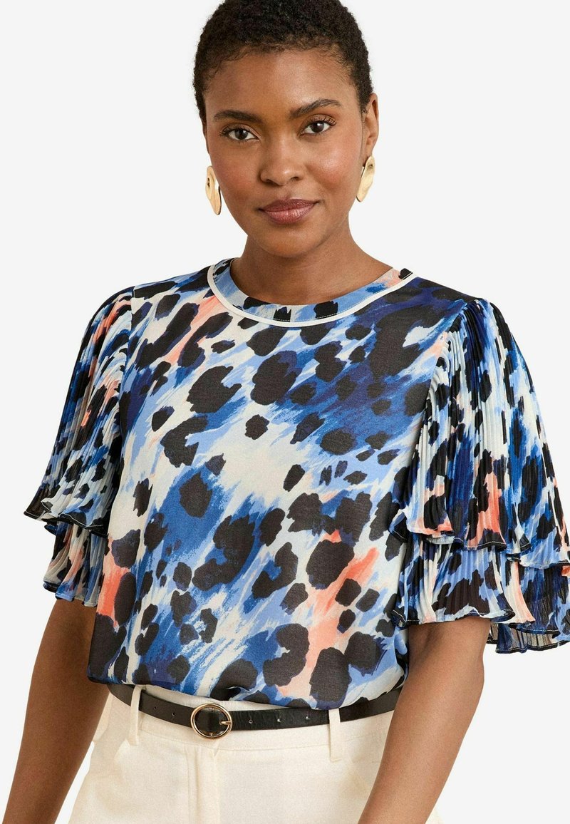 Lühikeste varukatega blouse, mis on valmistatud kergest kangast. Sellel on sinine, must ja korallvärvi abstraktne muster, pleatitud varrukad ja ümmargune kaelus.