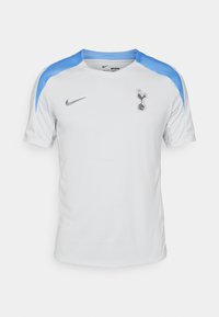 Biely futbalový dres Nike s svetlomodrými ramennými akcentmi, obsahujúci klubové logo a textúrovanú tkaninu pre priedušnosť. Krátke rukávy.