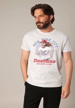 Grijze katoenen t-shirt met een kleurrafische afbeelding van een rennende skelet. Tekst leest "New York City" en "Deeluxe Running Club." Korte mouwen.