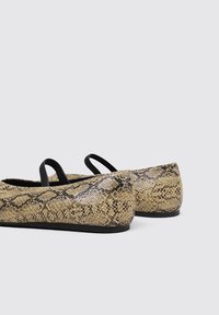 Texturierte beige Ballettschuhe mit einem Schlangenledermuster, schwarzen Akzenten und kleinen Knöchelriemen. Ausgestattet mit einer runden Zehe und flacher Sohle.