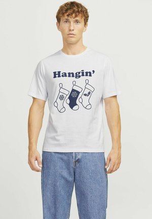 Witte katoenen t-shirt met drie geïllustreerde kerstvoorraden in blauw en marineblauw, met de tekst "Hangin'" boven het ontwerp.