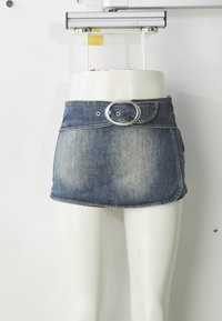 Jeans mini krilo z blagim modrim pranjem, srebrnim okroglem pasom in podrobnim šivanjem. Ima eleganten, oprijet dizajn.