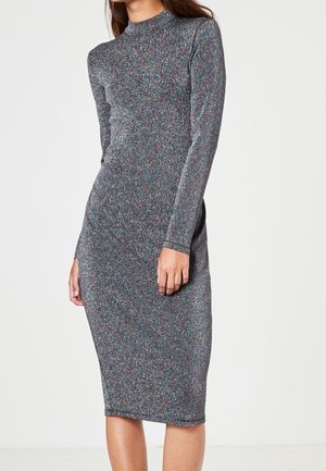 Robe midi en maille multicolore, avec manches longues et col montant. La texture est douce et légèrement extensible avec une silhouette ajustée.