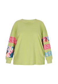 T-shirt oversize a maniche lunghe di colore verde chiaro, con strisce di tessuto a motivi in rosa, blu e designs floreali su entrambe le maniche.