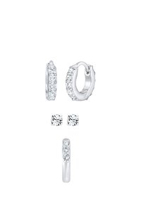 Pendientes de aro plateados con cristales transparentes, con una superficie lisa y un pequeño cierre articulado, junto a pendientes de botón con un diseño de cristal similar.